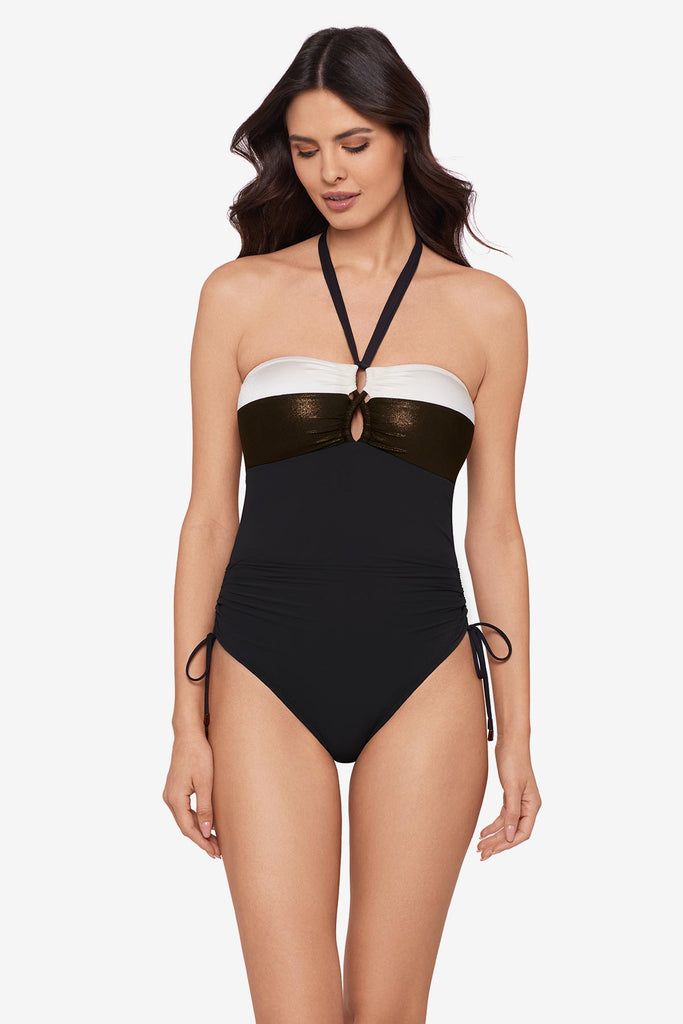 Woman wearing a black halter top swimsuit with a white stripe along the chest
