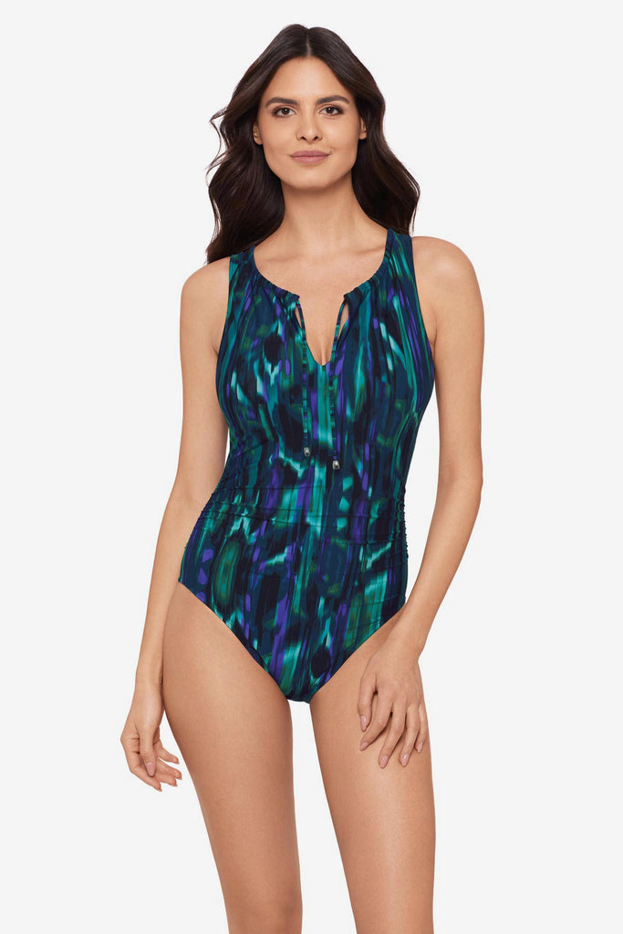 Woman wearing a green tie-dyed one -piece swimsuit with a tie at the neckline