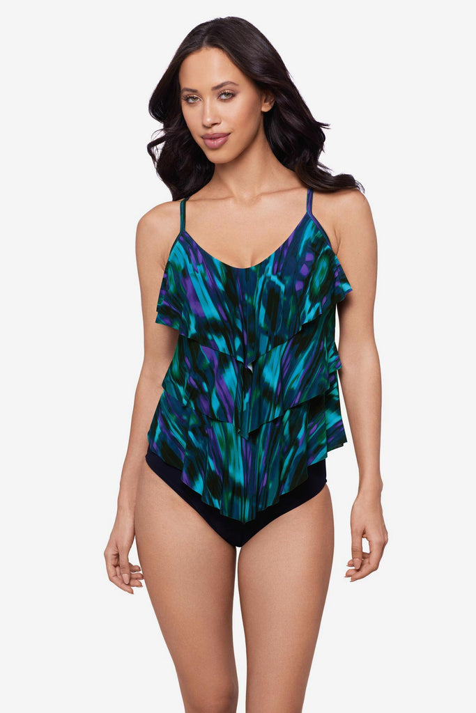 Woman wearing a blue and green pattern tankini top with ruffles