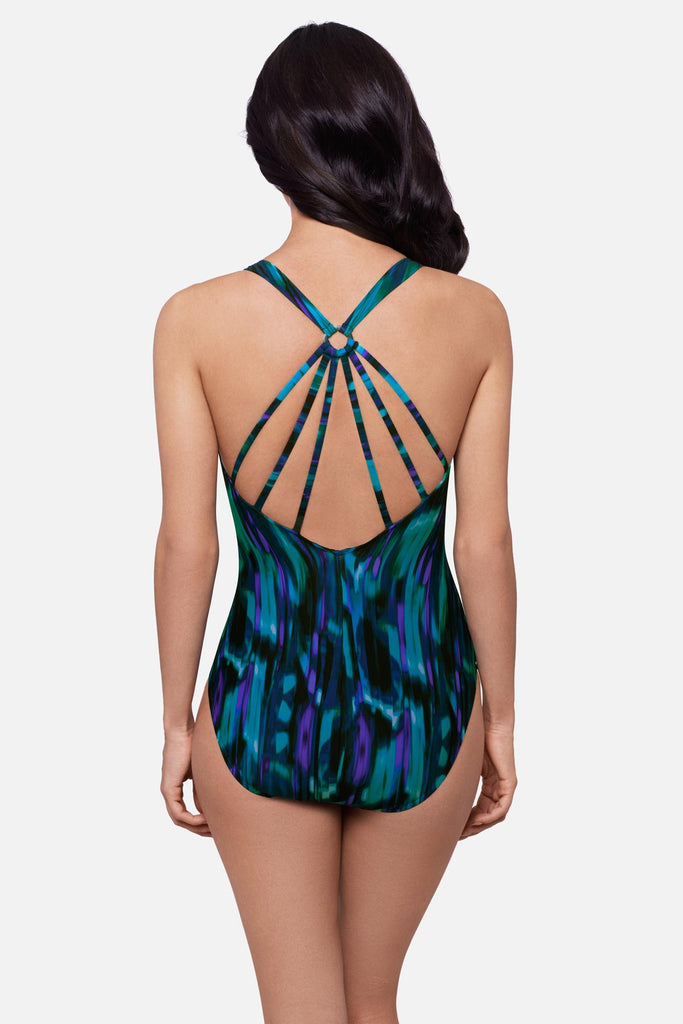 Woman turned away wearing a blue and black tie-dye printed swimsuit with an X back