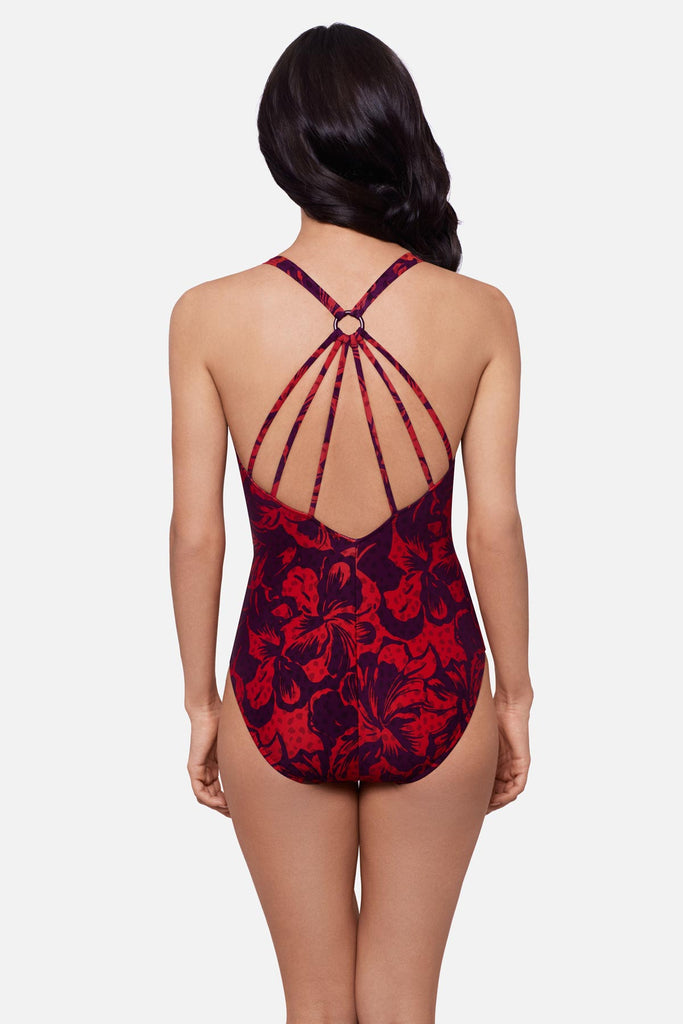 Woman turned away wearing a red floral printed one-piece swimsuit with an X back