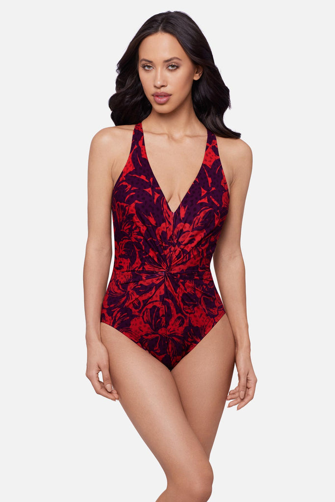 Woman wearing a red floral printed one-piece swimsuit with a V neckline
