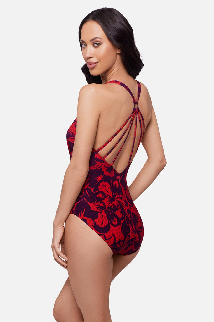 Woman turned left wearing a red floral printed one-piece swimsuit with a V neckline