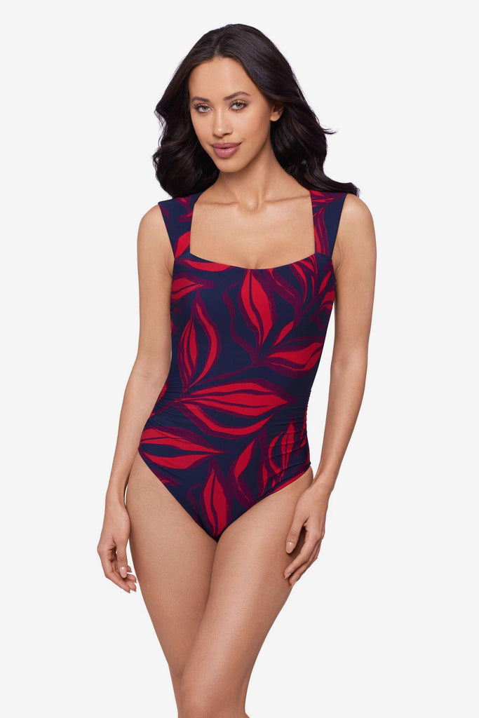 Woman wearing a red leaf printed one-piece swimsuit with short sleeves