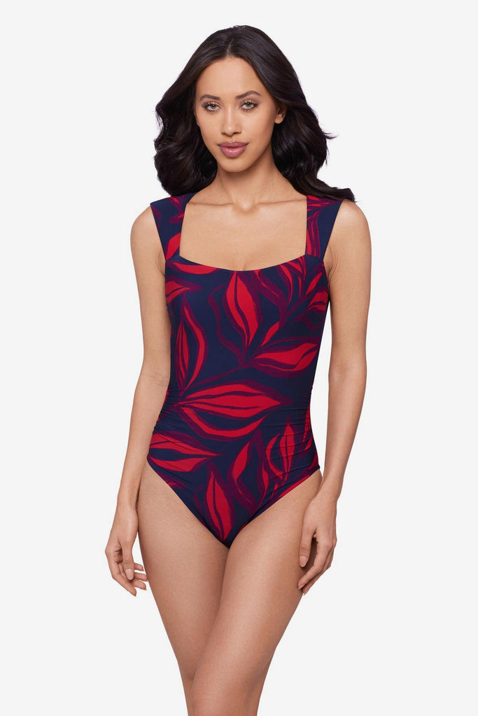 Woman wearing a red leaf printed one-piece swimsuit with short sleeves