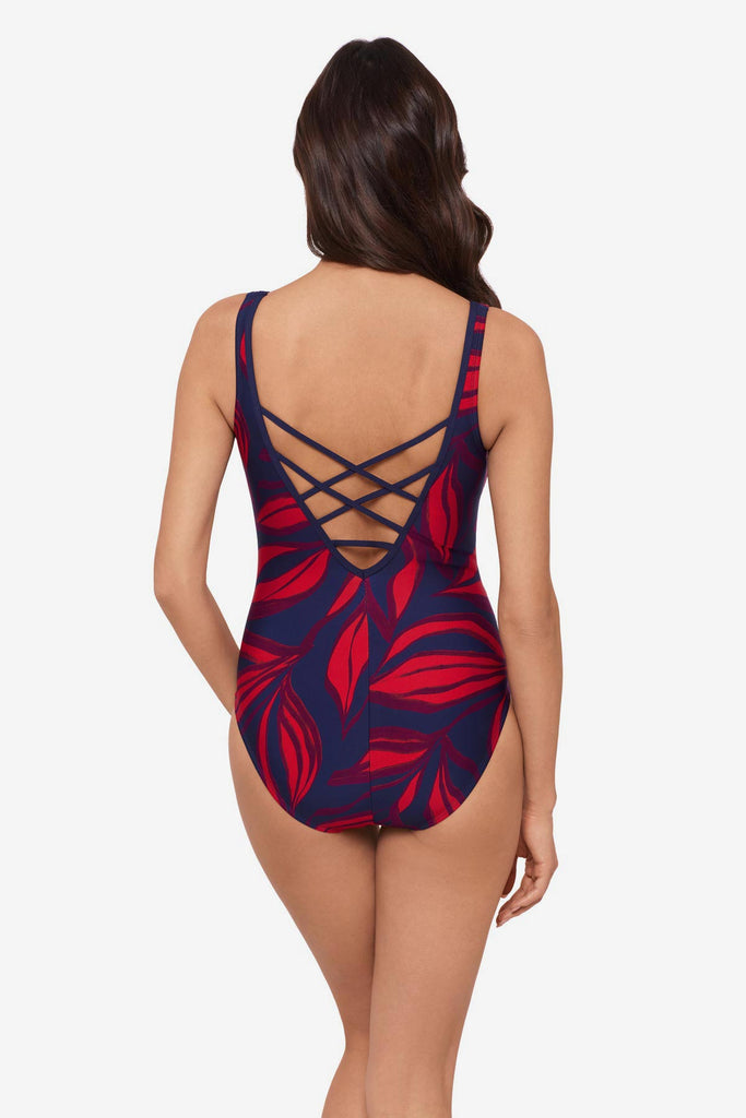 Woman wearing a red leaf printed one-piece swimsuit with an X back