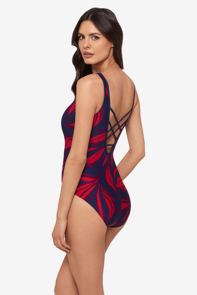 Woman turned right wearing a red leaf printed one-piece swimsuit with an X back