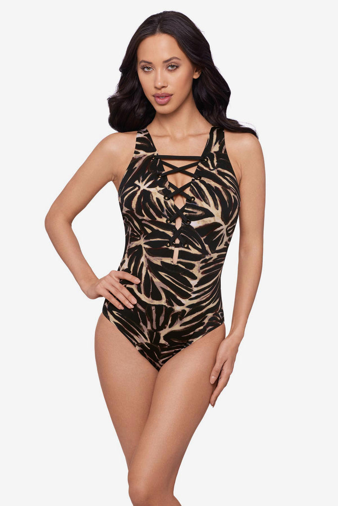 Woman wearing a brown leaf printed one-piece swimsuit with an X detail front