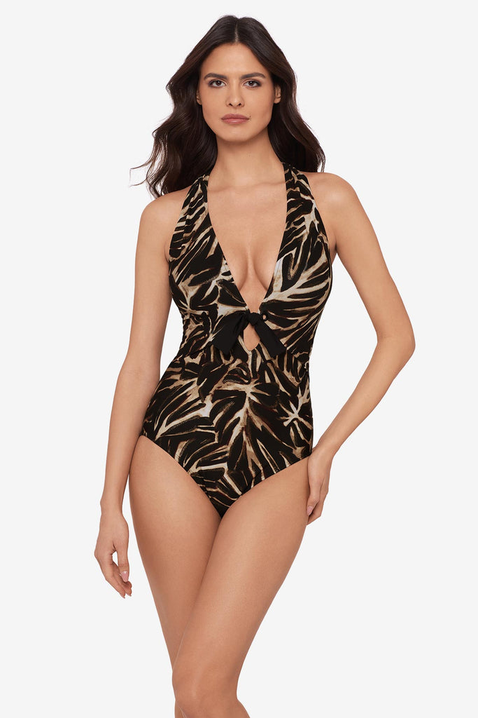 Woman wearing a brown leaf printed one-piece with a deep V neckline