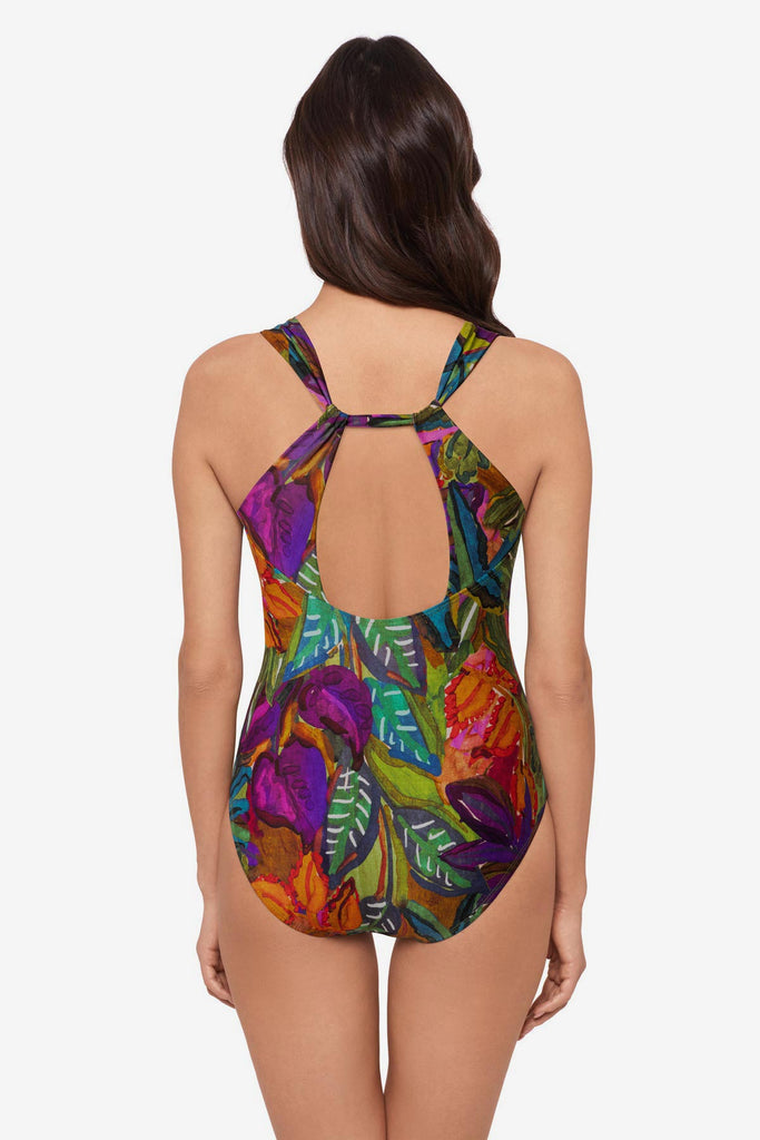 Woman turned away wearing a multicolored jungle printed one-piece swimsuit