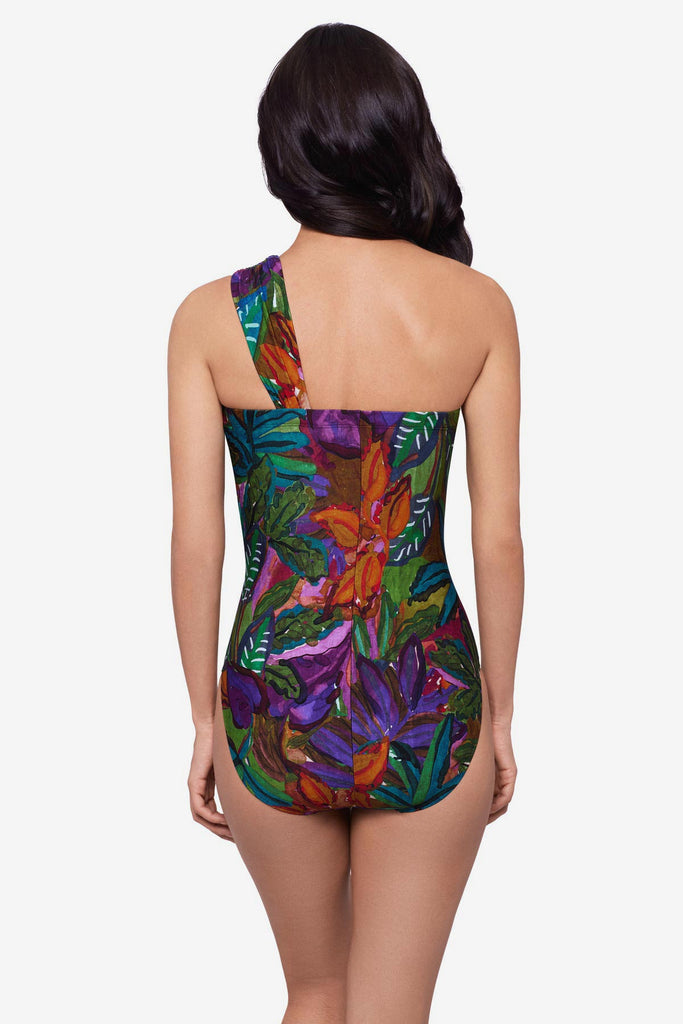 Woman turned away wearing a jungle printed one-piece swimsuit with an asymmetrical neckline