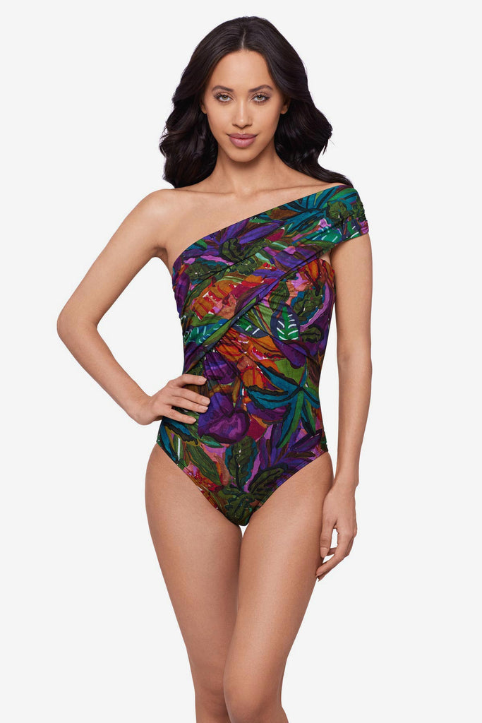 Woman wearing a jungle printed one-piece swimsuit with an asymmetrical neckline