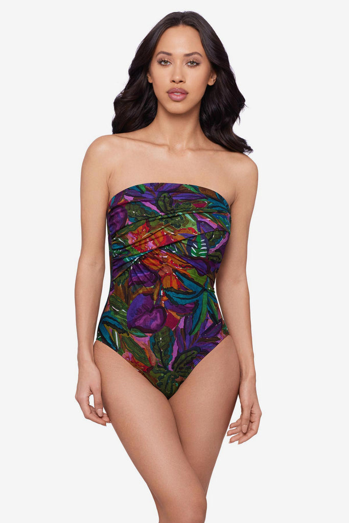 Woman wearing a jungle printed one-piece swimsuit with a bandeau neckline