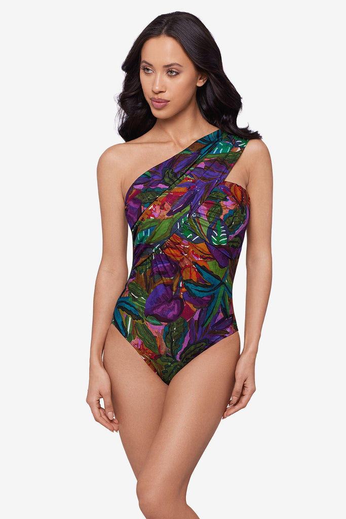 Woman wearing a jungle printed one-piece swimsuit with an asymmetrical neckline