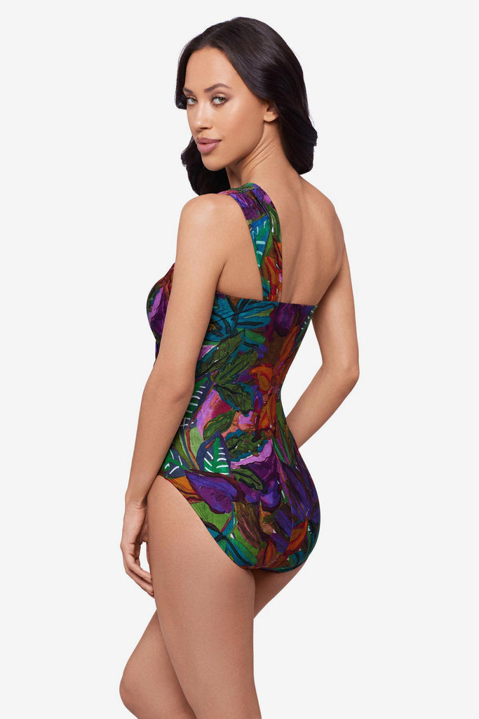 Woman turned leftwearing a jungle printed one-piece swimsuit with an asymmetrical neckline
