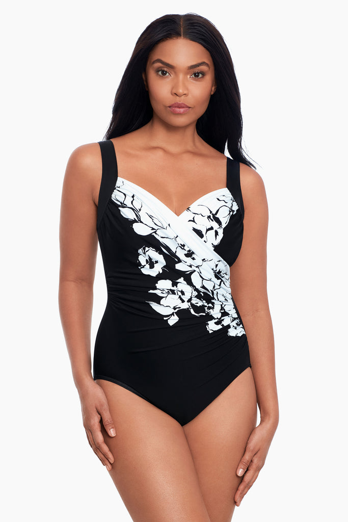 Woman wearing a miracle suit one piece swim suit.