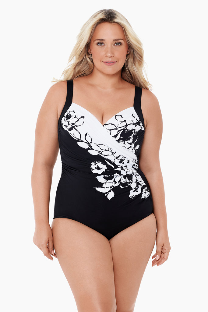 A young woman wearing a printed black and white swim suit.